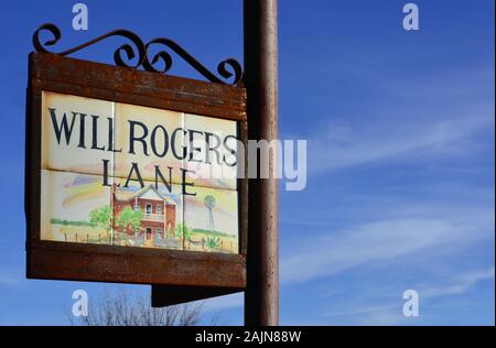 Close up of pictorial tiles depicting Garrett house framed in an ornate metal sign holder reading Will Rogers Lane, against a blue sky in Tubac, AZ Stock Photo