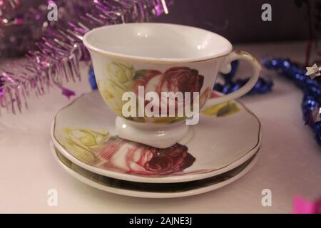 white porcelain cup with red rose print on stay empty prepare for morning tea Stock Photo