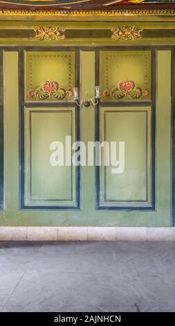 Beautiful elegant carved frames on green wall with ornate border with white marble tiled floor, in abandoned old building Stock Photo