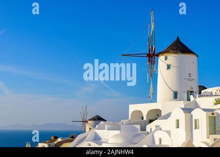 Windmill and traditional white buildings facing Aegean Sea in Oia, Santorini, Greece Stock Photo