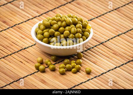 Canned green peas in the bowl on wood background Stock Photo