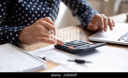 Woman using calculator counting finances calculate bills pay online, closeup Stock Photo
