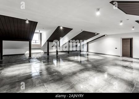 Empty unfurnished loft mansard room interior with wooden columns and wet concrete floor on roof level in black and whote style color Stock Photo