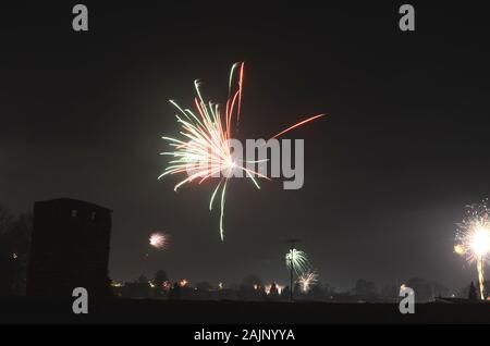 New Year's firewrok seen over a semirural settlement at night. Stock Photo