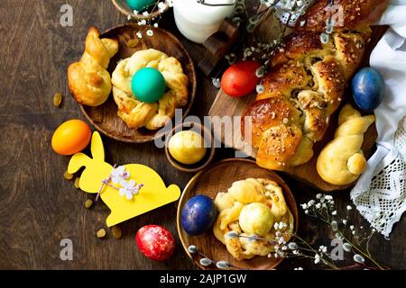 Easter holiday table. Easter cakes and colored eggs on a wooden table. Top view flat lay background. Stock Photo
