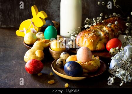 Easter holiday table. Easter cakes and colored eggs on a wooden table. Stock Photo