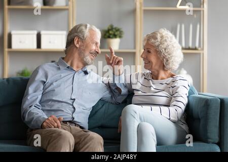 Pretty 60s elderly family sitting on couch enjoy talk Stock Photo