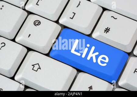 A keyboard with the word Like written in white lettering on a blue enter key. Social media and Facebook networking concept. England, UK, Britain Stock Photo