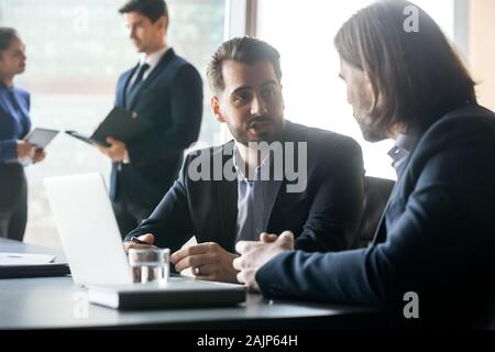 Businessmen brainstorm working together on laptop at briefing Stock Photo