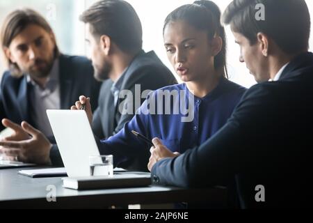 Multiethnic employees discuss business ideas collaborating at meeting Stock Photo