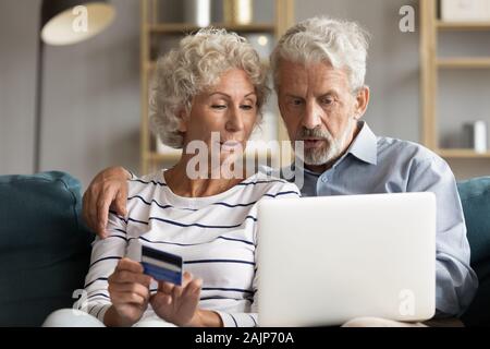 Senior couple use online websites bank credit card buying online Stock Photo