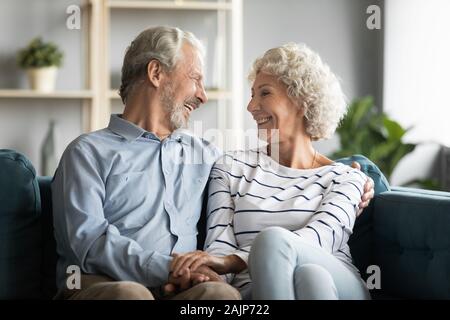 Grandfather and grandmother holding hands chatting laughing spend time together Stock Photo