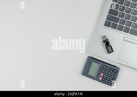 A laptop keyboard on it is a flash drive, and next to a calculator. Stock Photo
