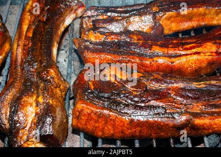 Spicy glazed pork ribs grilling on hot coals of a barbecue Stock Photo