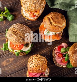 Assorted sandwiches on wooden table Stock Photo