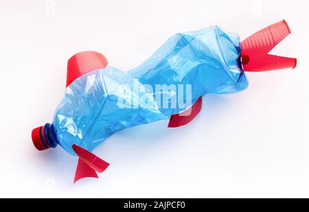 Kill the environment concept. Plastic bottle recycled in a fish figure on white background Stock Photo