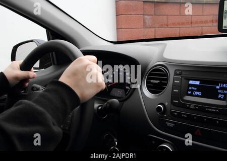 a modern dashboard in a car with a driver behind the wheel Stock Photo