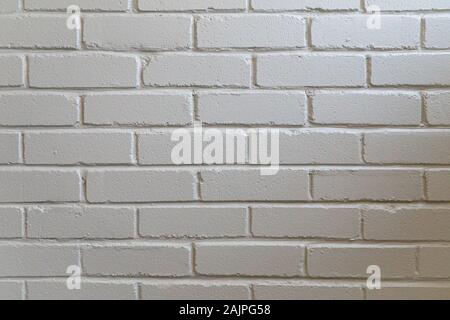 Close-up of a white painted brick wall with subtle surface texture and horizontal lines, evenly lit for a clean minimalist background Stock Photo