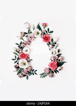Creative layout with pink flowers, green leaves and quail eggs. Happy easter concept. Stock Photo