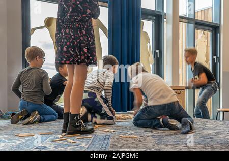 NIJMEGEN / NETHERLANDS-SEPTEMBER 13, 2019: Young children playing with each other in school and  sitting and standing on the floor Stock Photo