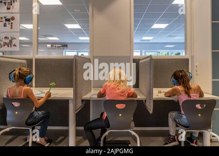 NIJMEGEN / NETHERLANDS-SEPTEMBER 13, 2019: children working concentrated in a modern school environment. They are working alone without a teachers Stock Photo