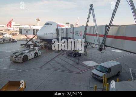 Airplane on tarmac waiting for people to board. The walkway tunnel is connected. Stock Photo