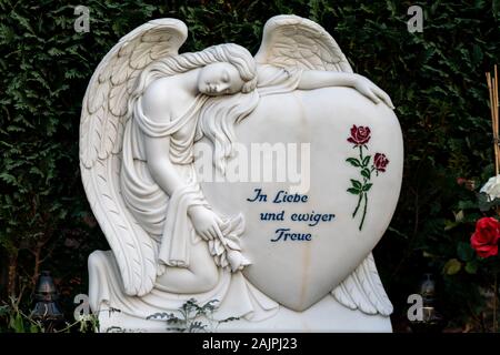 Friedhof Tegel, Berlin, Germany -november 29, 2018:  A heart with a mourning angel and a red rose reading 'eternal love and fidelity' Stock Photo