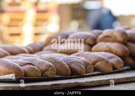 Whole wheat rolls are arranged in a tray, isolated on a blurred background. Stock Photo