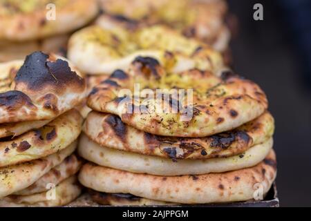 Authentic, flat bread with Za'atar, baked, stacked. The market in Jerusalem. Arab style. Blurred black background. Stock Photo