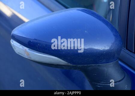 rear-view mirrow backside of a dirty blue colored car with light reflections, blue car rear-view mirrow Stock Photo