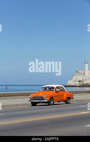 Old Classic Car, On the Malecon, Castillo del Morro (background), Havana, Cuba Stock Photo
