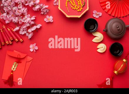 Chinese New Year flat lay red background with assorted festival decorations. Traditional characters means abundant of wealth, prosperity and luck, cop Stock Photo