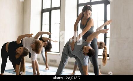 Yoga teacher training man, doing Utthita Trikonasana exercise at lesson Stock Photo