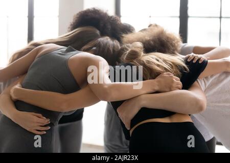Diverse people, fitness center staff embracing, standing in circle Stock Photo