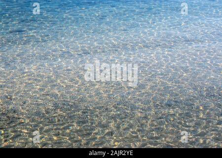 Crstal clear water of the adriatic sea, beach shot. Small white and blue waves on a rocky pebble beach Stock Photo