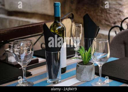 Served table in a summer cafe on a street in the old part of the tower Kotor, Montenegro. Stock Photo