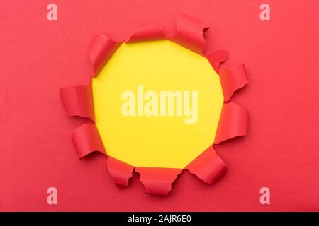 Red paper with ripped hole in the middle background Stock Photo