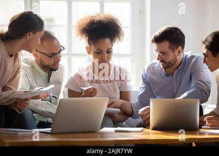 Multiethnic diverse students brainstorm preparing for exam together Stock Photo