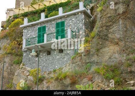 ancient stone cottage built on a Ligurian cliff overlooking the Cinque Terre sea in Italy Stock Photo