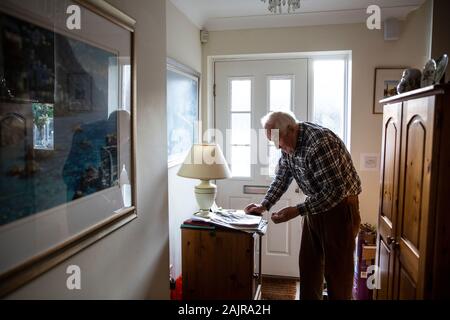 87 year old elderly man, living alone, stood in his hallway, England, United Kingdom Stock Photo