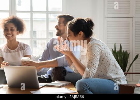 Overjoyed multiethnic employees have fun brainstorming indoors Stock Photo