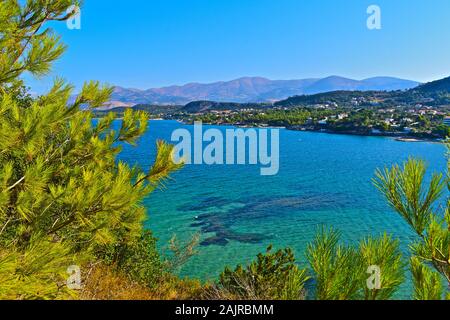 A stunning elevated view across a pretty bay near Lassi, looking towards Argostoli, with mountains in the background.  Tree in foreground. Stock Photo