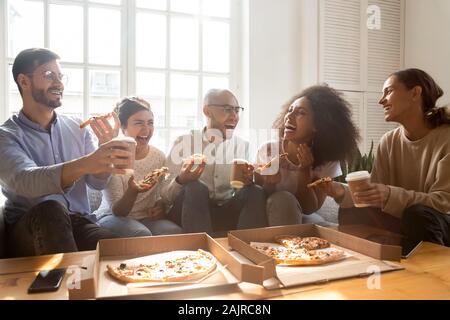 Excited multiracial young people have fun enjoying pizza Stock Photo