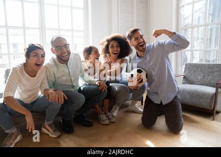 Excited multiracial millennial people watch football cheering Stock Photo