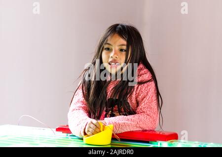 Concentrated and enthusiastic girl plays table hockey Stock Photo