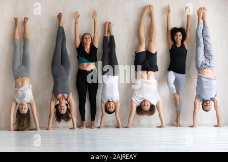 Happy diverse people doing handstand, fitness center staff portrait Stock Photo