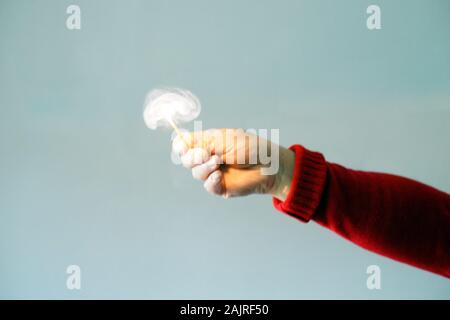 Woman in red lighting a match. Match and fire concept. Stock Photo