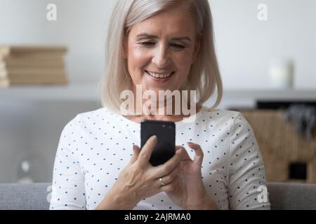 Modern elderly woman using smartphone browsing internet Stock Photo