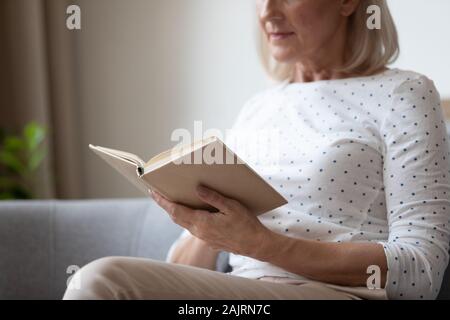 Close up of senior woman reading book at home Stock Photo