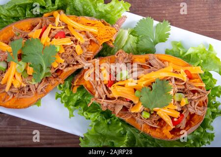 delicious spicy pulled pork stuffed sweet potato skin yam dish Stock Photo